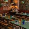 Super-Seat | Ein gemütliches Restaurant mit grünen Holztischen | Groene houten tafels, vintage inklapbare legerbanken, bonte glazen kandelaars, zwart-witte tegels. | Horecameubilair