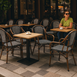 Super-Seat |Vrouw in groen aan buitentafel, zwarte gevlochten stoelen met armleuning op stenen terras (Stühle, Tafeln und Barkrukken im Café de Paris). | Horecameubilair