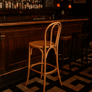 Super-Seat | Vienna Thon no 18 wood bar stools | Natural wood, curved back, at dark wood bar on black and white tile floor. | Hospitality Furniture