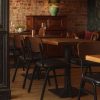 Super-Seat | Jody hospitality design chairs black/brown | Black and brown stackable chairs made of wood/leather, wooden tables, leather bench, brick wall. | Hospitality Furniture
