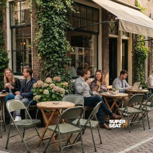 Super-Seat | Metal army green folding chairs and tables on cobblestones, people enjoy outside. | Hospitality Furniture